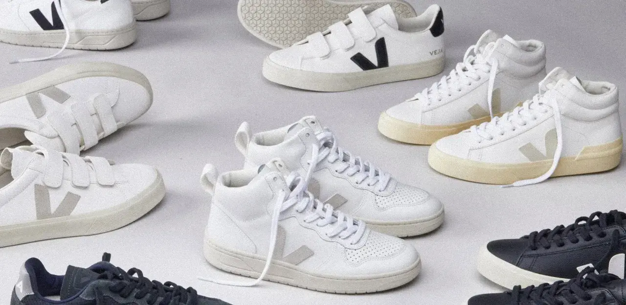 Białe i granatowe sneakersy Veja, niektóre na rzepy, inne sznurowane. Zobacz, co to za firma, która tworzy stylowe i ekologiczne obuwie.
