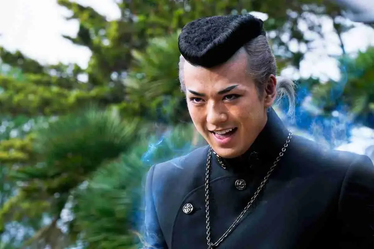 Un jeune homme au style unique, peut-être dans des films et séries TV avec Mackenyu, dégage une énergie mystérieuse.