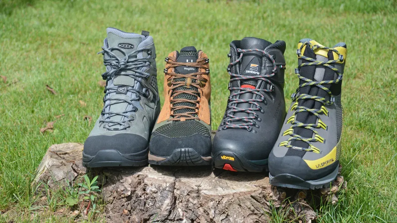 Four hiking boots, showcasing what boots are made of, sit on a log. Materials include leather, mesh, and rubber soles.