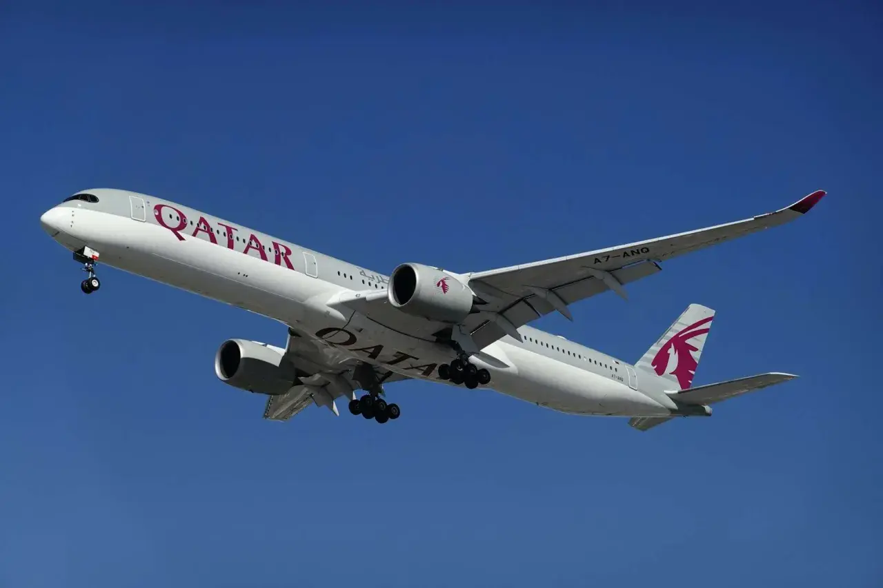 Samolot Qatar Airways z wysuniętym podwoziem, gotowy do lądowania. Pamiętaj o limitach bagażu podręcznego!