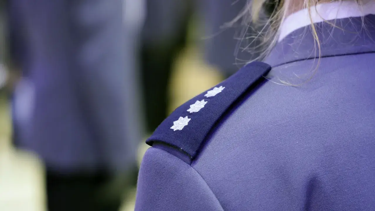 Trzy białe gwiazdki na granatowym naramienniku munduru policyjnego. To jeden ze sposobów, by poznać, jakie są stopnie w policji.