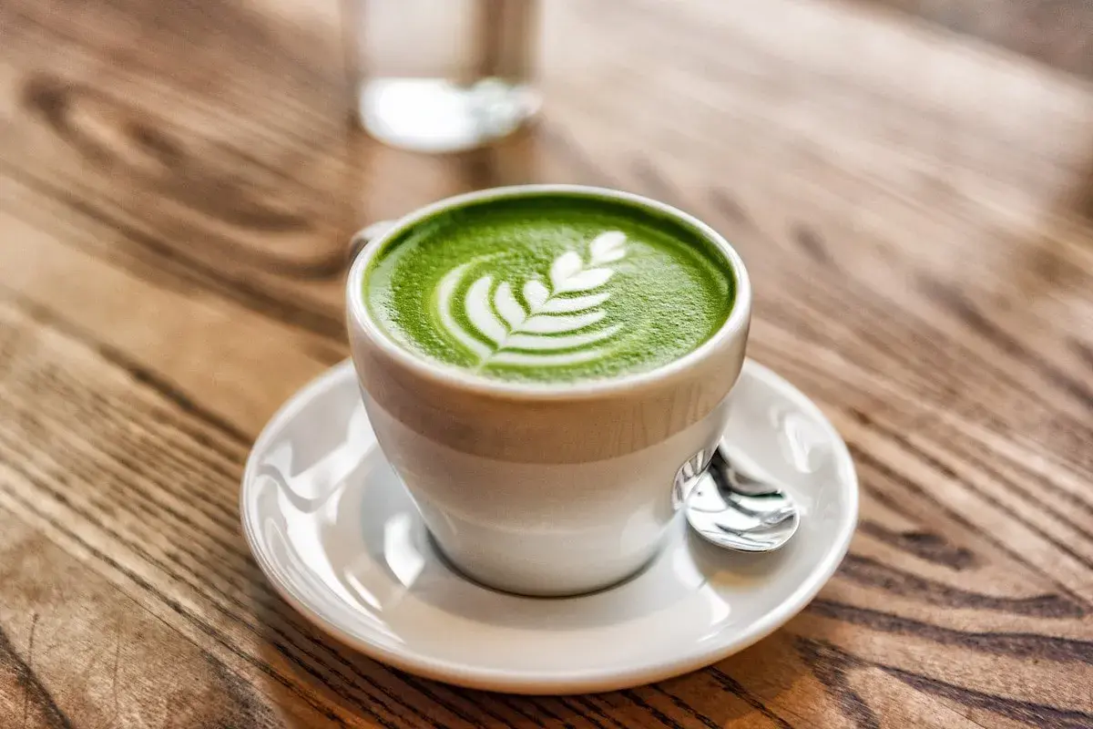 Tazza di matcha latte con schiuma decorata, un esempio di cos'è il latte in una bevanda cremosa e deliziosa.
