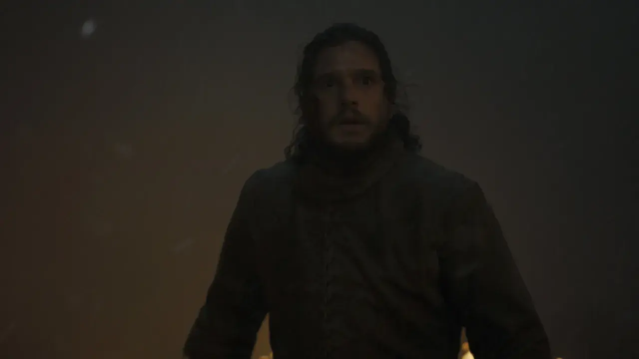 Jon Snow zszokowany w "Gra o tron s06e02". W tle płomienie i śnieg.