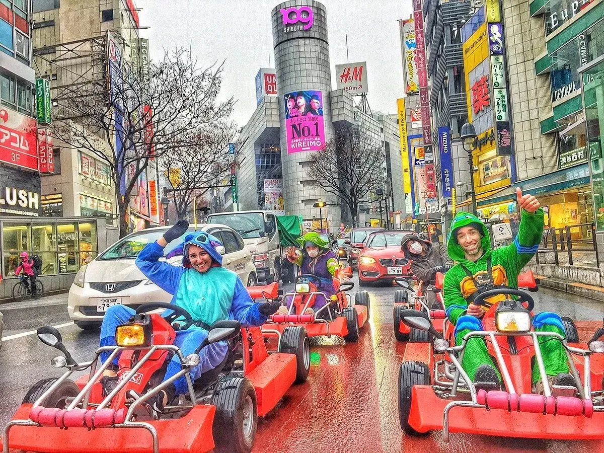 Folk i dräkter kör gokart genom Shibuya Crossing i Tokyo.
