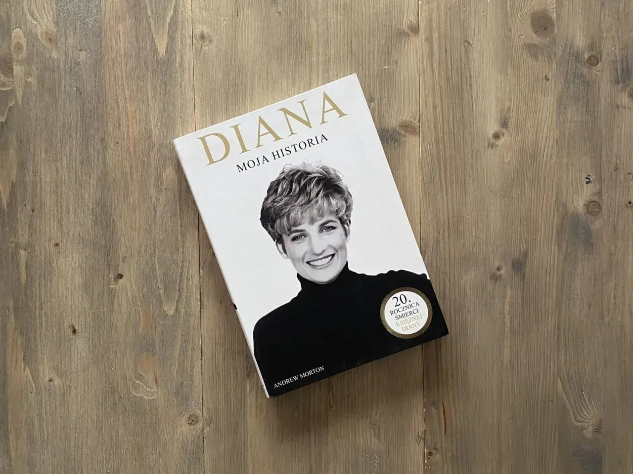 Okładka książki "Diana. Moja historia" z portretem księżnej Diany na drewnianym tle.