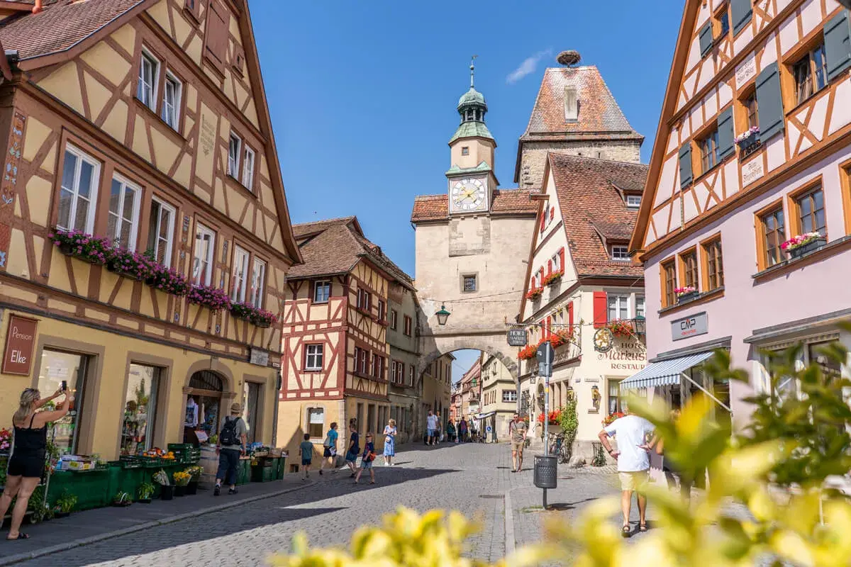 Entdecke die charmanten Gassen von Rothenburg ob der Tauber. Geheimtipps für deinen Besuch: Fachwerkhäuser, ein Marktplatz mit Uhrturm und blumengeschmückte Fenster.