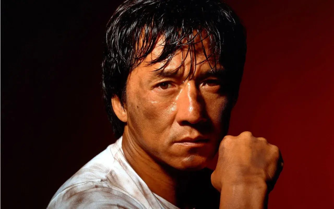 Jackie Chan, med svettig panna och en knuten näve, redo för action i sina filmer.