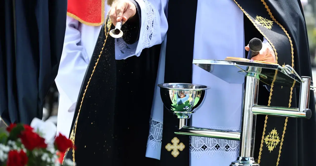 Osoba w szatach liturgicznych sypie ziarna. Czy to apostata, kto to? Ceremonia z mikrofonem i kielichem.