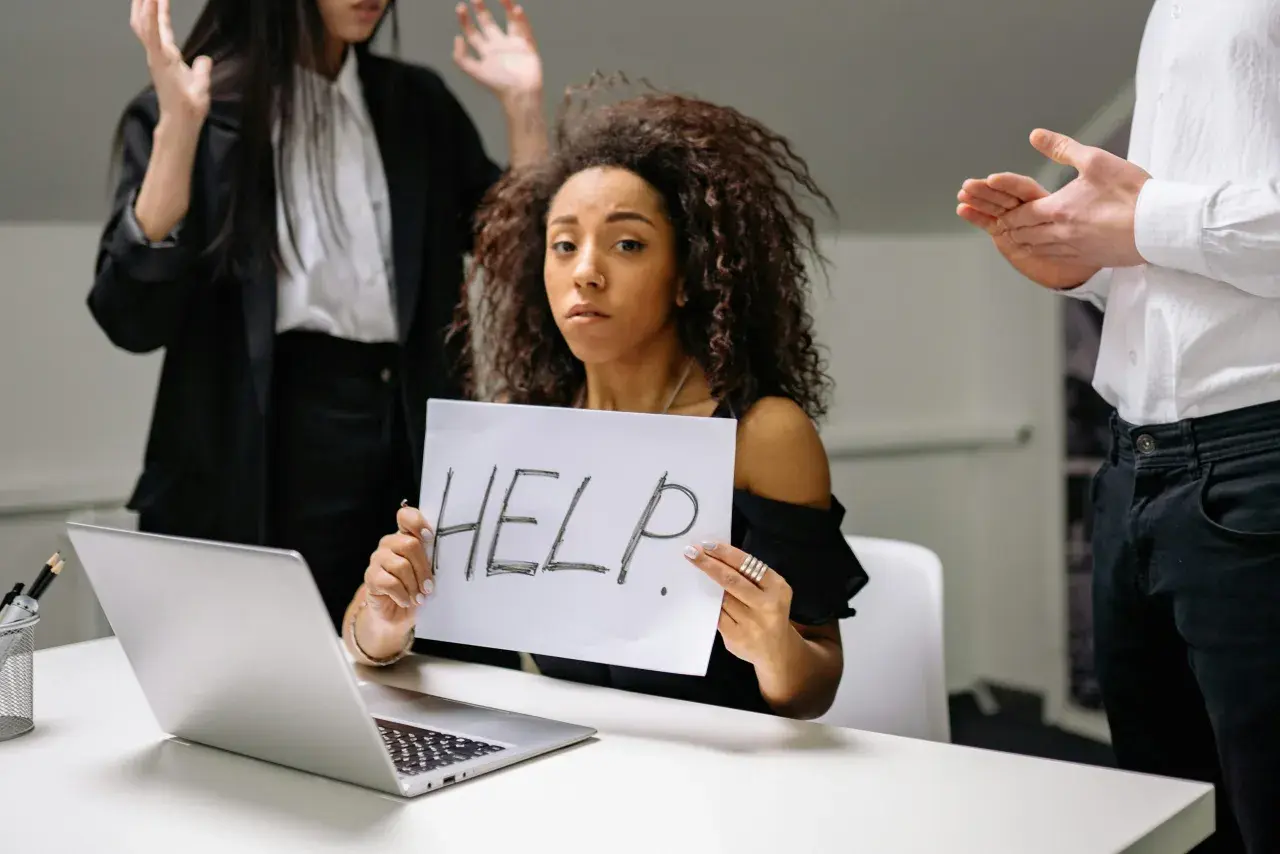 Kobieta z kartką "HELP" szuka sposobu, jak pozbyć się chwilówek. Wokół niej widać zaniepokojonych ludzi.