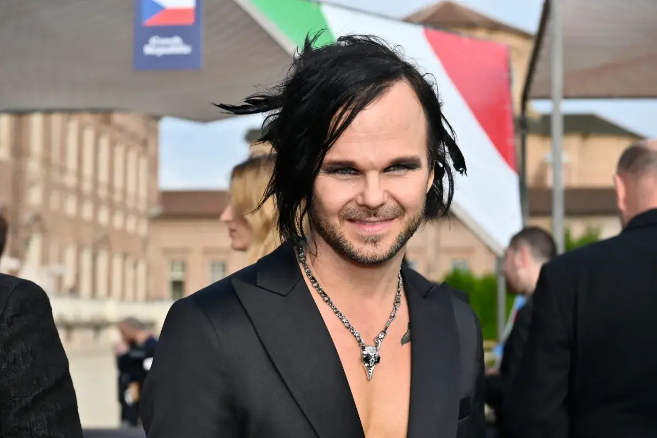 The Rasmus wokalista z charakterystyczną fryzurą i makijażem, w czarnym garniturze i naszyjnikiem z czaszką.