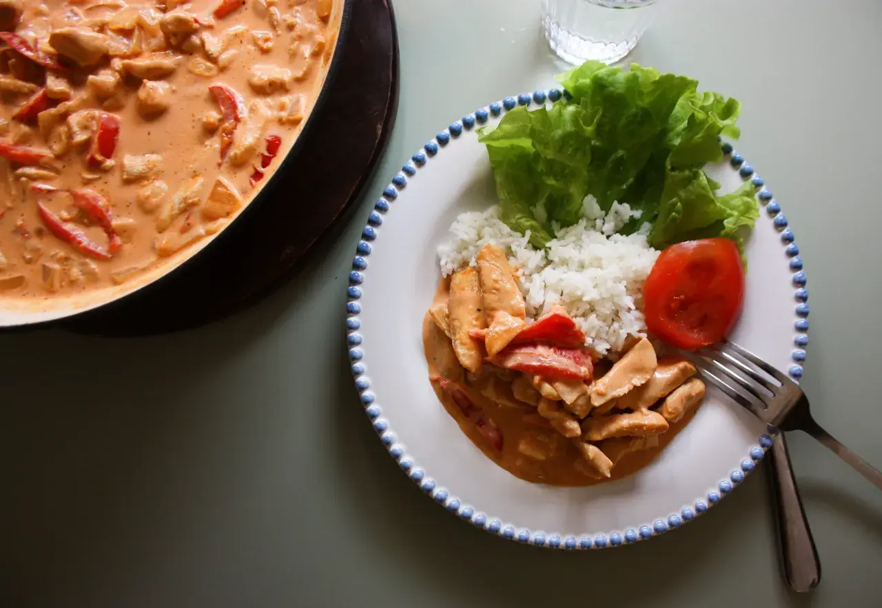 En krämig kyckling stroganoff med ris, sallad och tomat. En härlig middag som ser utsökt ut!