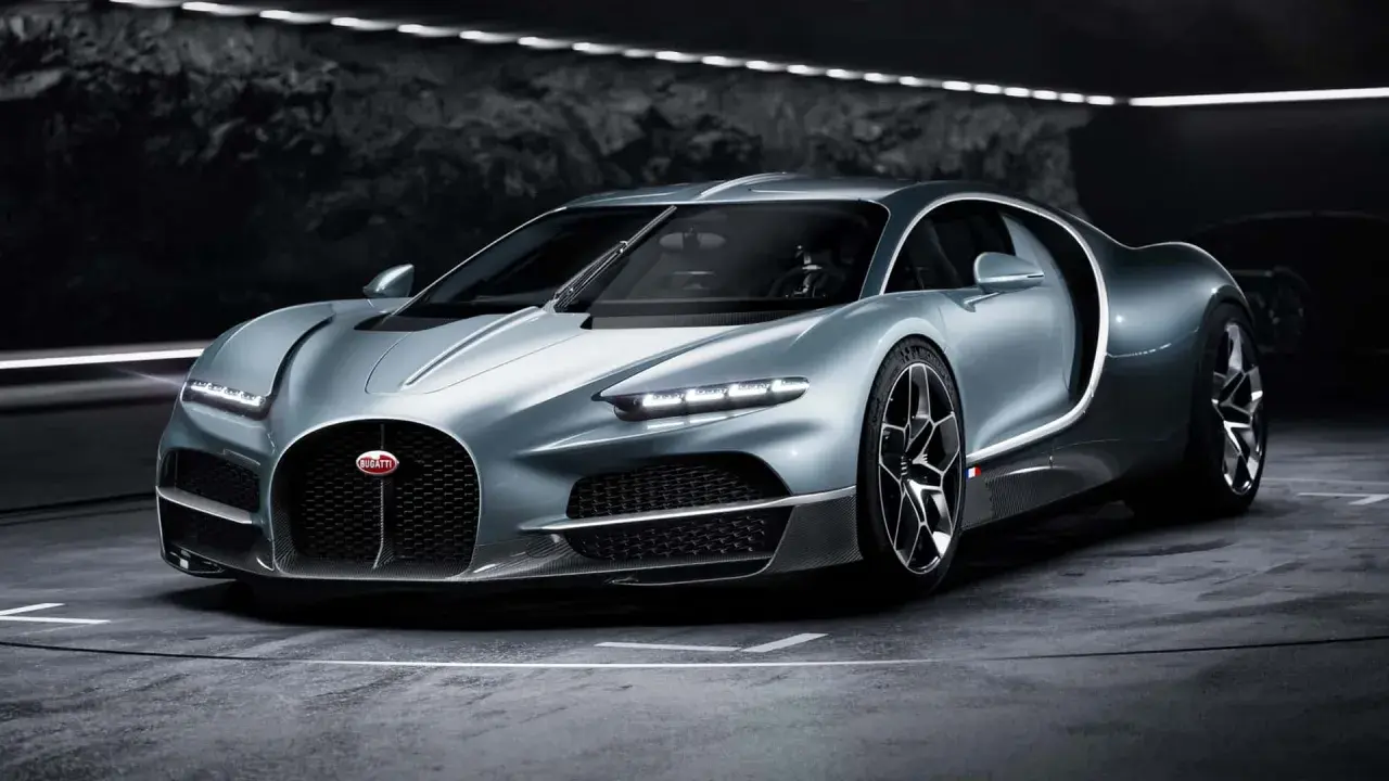 Srebrny Bugatti Tourbillon, symbol luksusu i mocy, prezentuje swoje aerodynamiczne linie w mrocznym wnętrzu.