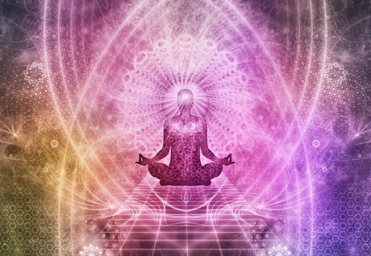 Sylwetka w pozycji lotosu, otoczona świetlistymi wzorami, symbolizująca przebudzenie energii kundalini.