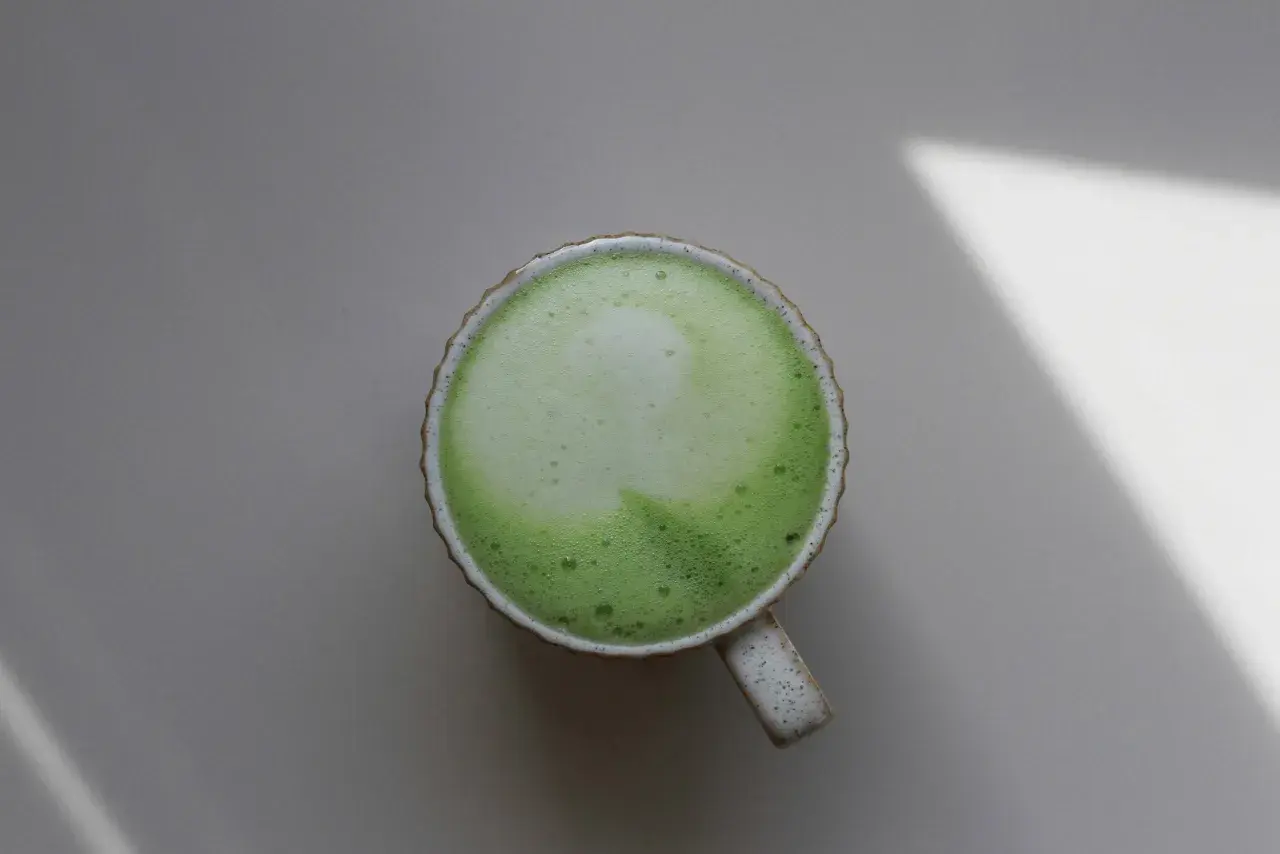 Eine Tasse cremiger Matcha-Latte, die die positive matcha wirkung psyche auf ruhige Weise unterstreicht.