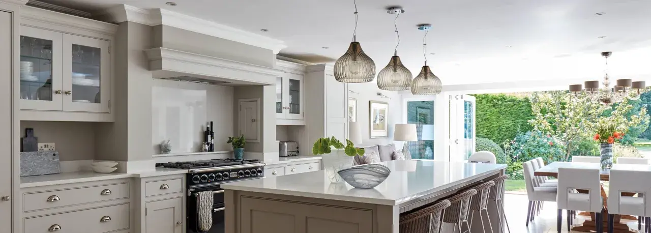 Elegant kitchen with island, dining area, and garden view. Showcasing latest kitchen designs with neutral tones and modern lighting.
