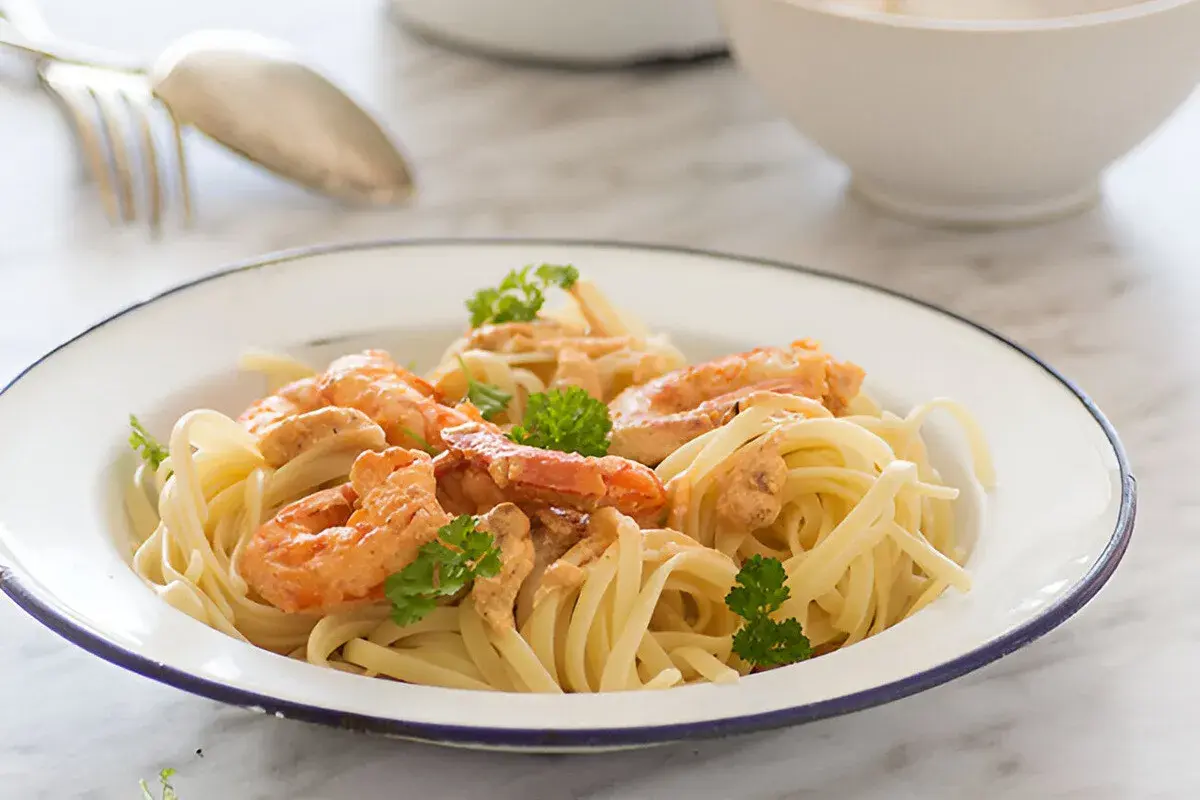Pasta con jugosa salsa de langostinos, coronada con perejil fresco. Un plato delicioso y fácil de preparar.