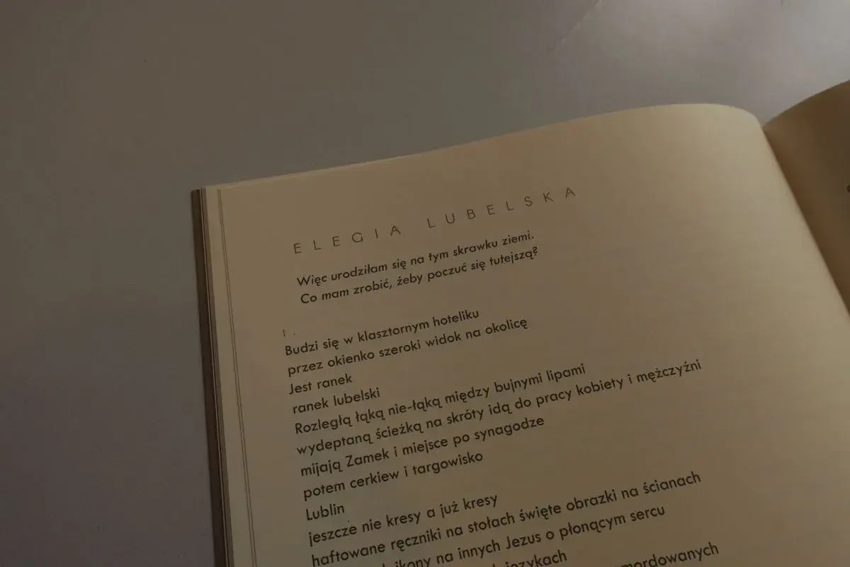 Otwarta książka z tekstem wiersza "Elegia Lubelska" Julii Hartwig.