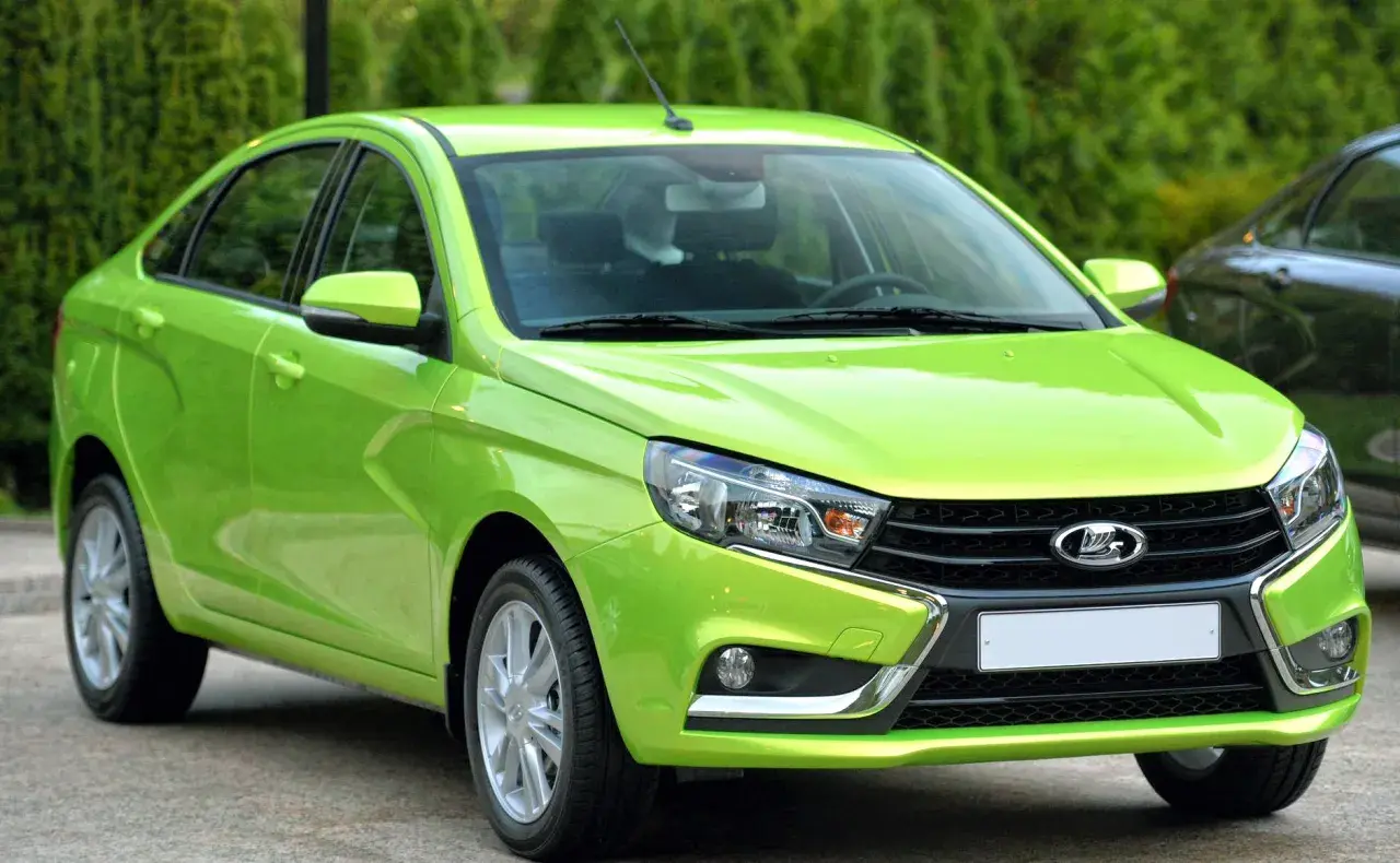En ljusgrön Lada Vesta står parkerad utomhus.