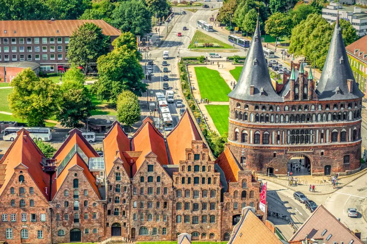 Blick auf Holstentor und historische Backsteinhäuser in Lübeck, ein Wahrzeichen vieler historischer Orte Deutschlands.
