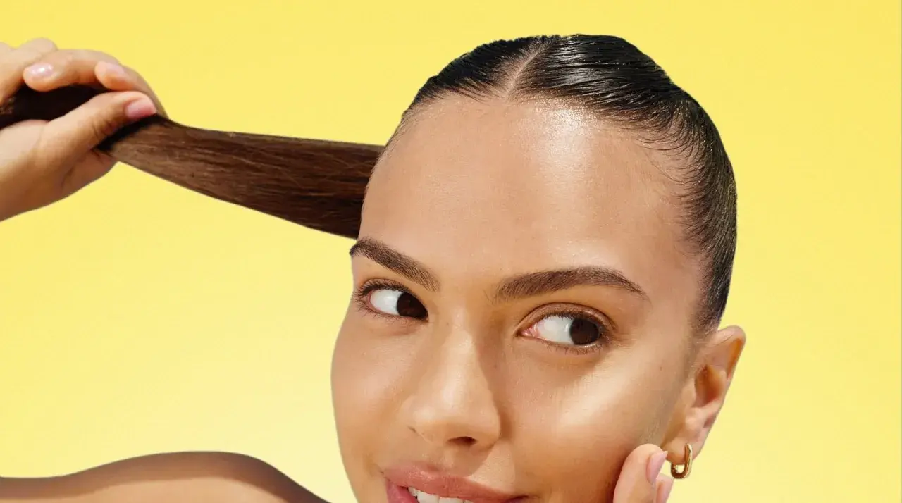 Mujer con cabello oscuro y liso, mostrando su brillo. ¡La vitamina C para el pelo es clave para un cabello radiante y saludable!