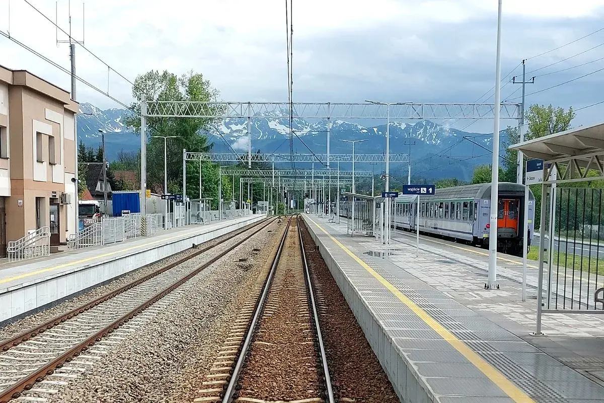 Stacja kolejowa z widokiem na góry. Pociąg gotowy do podróży na trasie Zakopane - Kraków. Czas przejazdu zależy od wybranego połączenia.