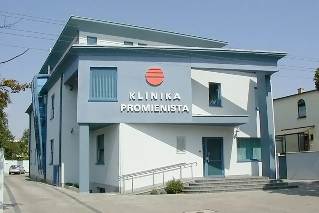 Nowoczesny budynek kliniki "Promienista" w Poznaniu z niebieskimi elementami i logo.