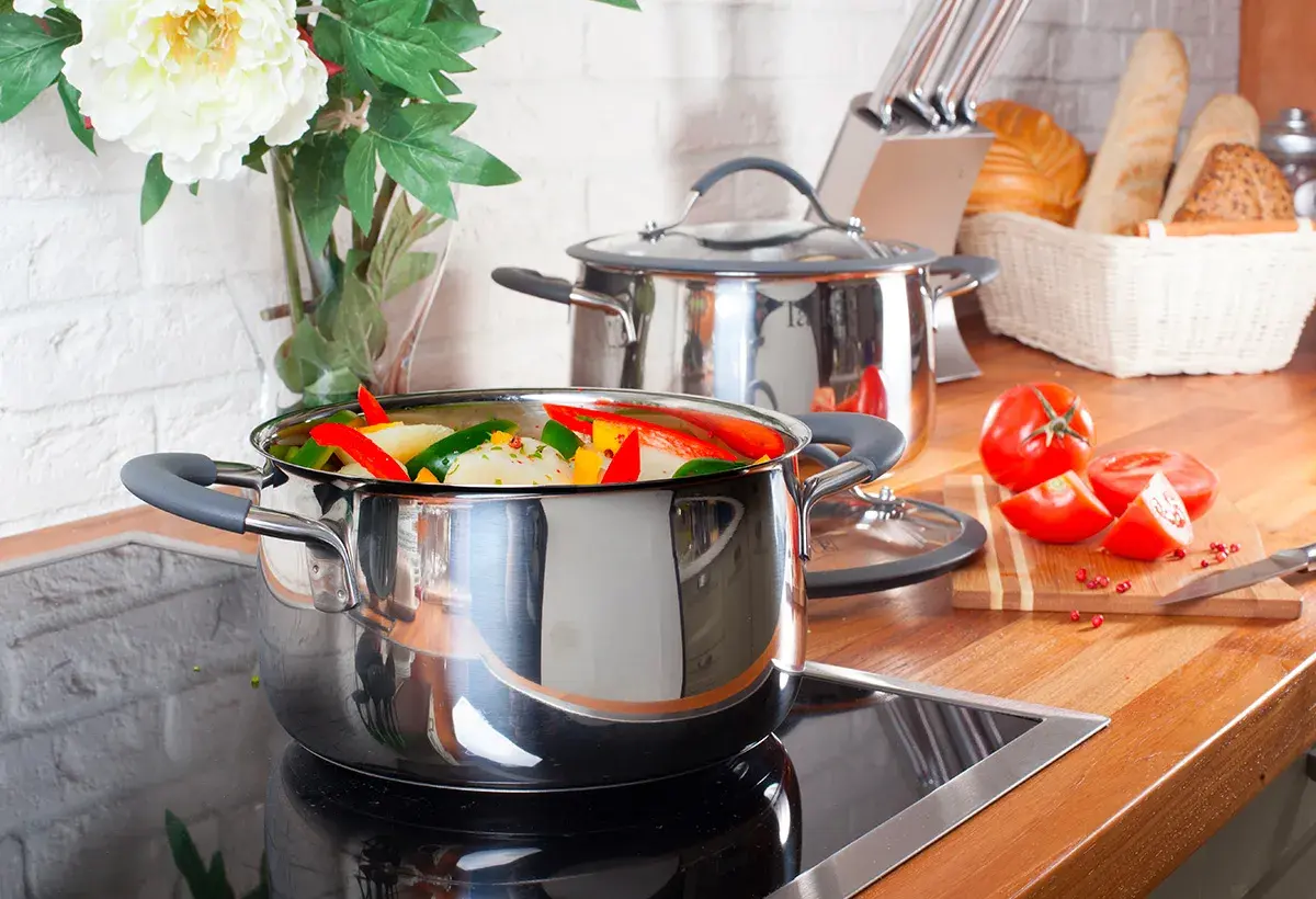 Casserole remplie de légumes colorés sur une plaque à induction, prête à être cuisinée.