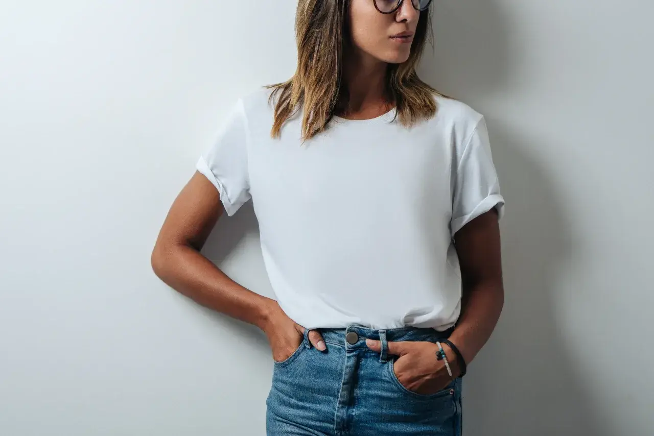 Frau in Jeans und einem weißen T-Shirt, das leicht gerollt ist. Das T-Shirt hat ein geringes Gewicht und ist bequem.
