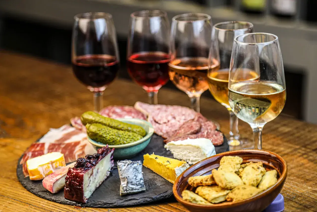 Calici di vini naturali a Firenze, accompagnati da salumi, formaggi e sottaceti. Un'esperienza gustosa.