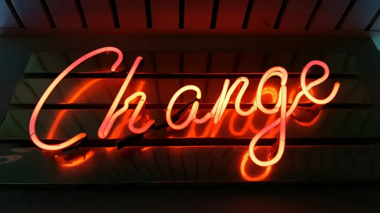 Néon rougeoyant "Change" pour illustrer comment changer de syndic en 5 étapes.