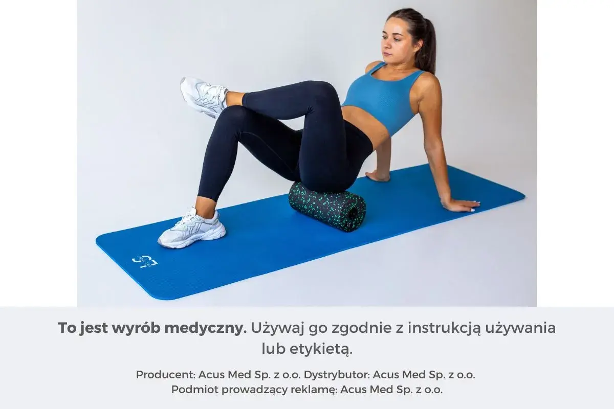Kobieta na macie ćwiczy, jak masować mięsień gruszkowaty za pomocą rollera.