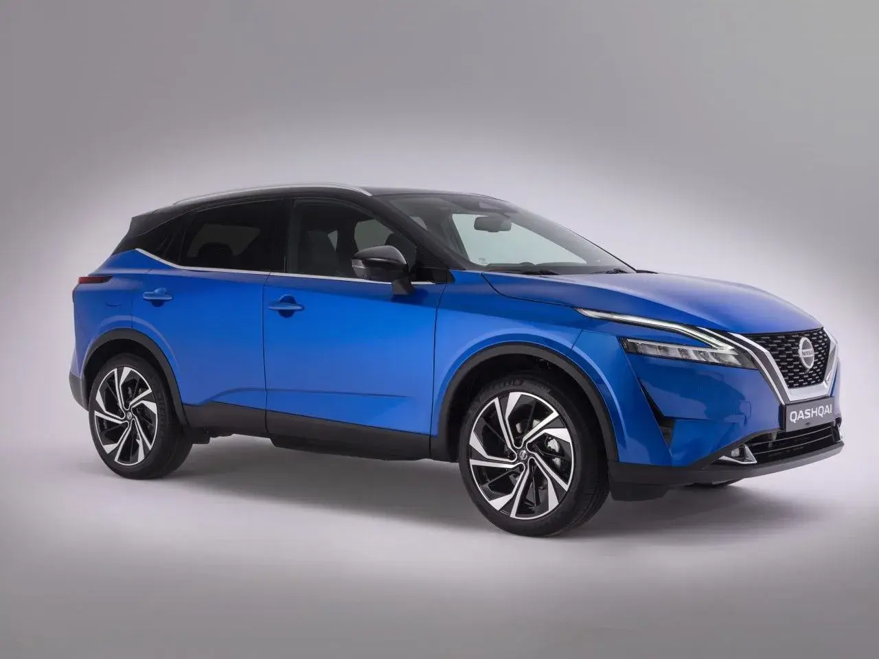 Niebieski Nissan Qashqai z eleganckimi felgami, które podkreślają jego rozmiar opon. Idealny do miasta i na dalsze trasy.
