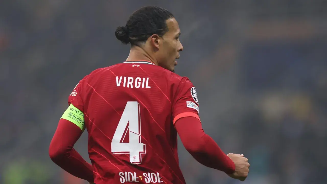 Piłkarz Virgil van Dijk w czerwonej koszulce Liverpoolu z numerem 4 i opaską "No to racism".