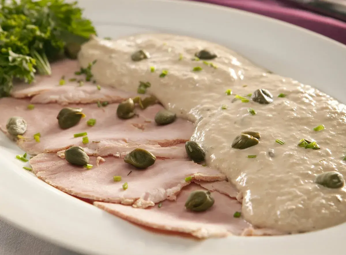 Fette sottili di carne rosa, guarnite con capperi e salsa cremosa, un classico vitel tonnè, origine piemontese.