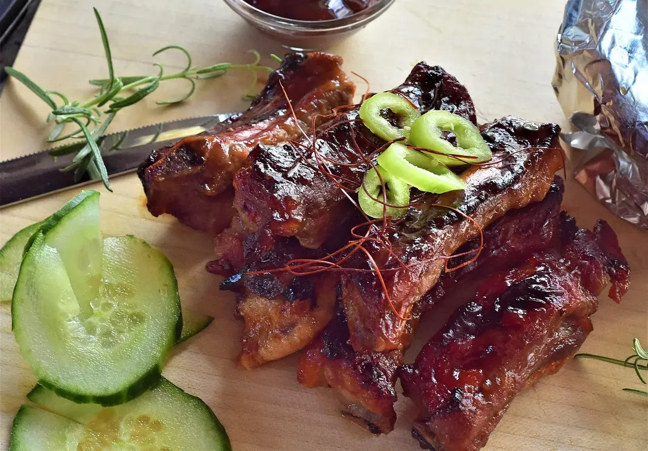 Délicieux ribs barbecue, prêts à déguster. Le temps de cuisson parfait pour des ribs tendres et savoureux. Accompagnés de concombre frais et de romarin.
