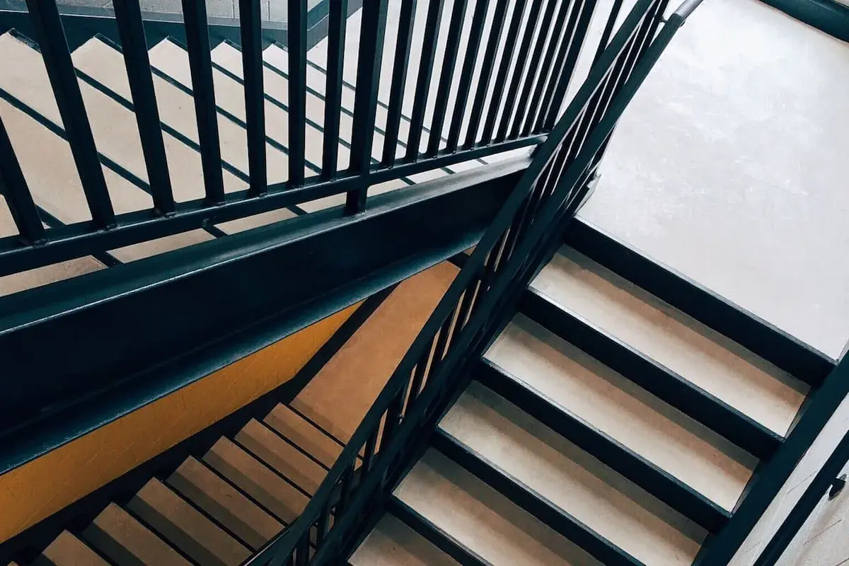 Escaleras modernas con barandillas oscuras y peldaños claros. Un lugar que invita a soñar con subir escaleras, alcanzando nuevas alturas.