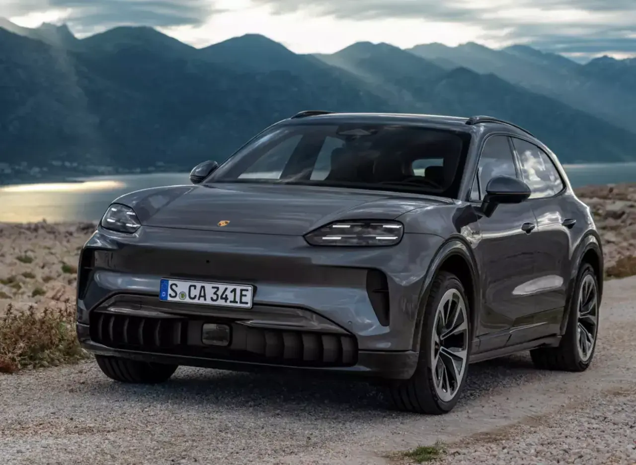 Nowy Porsche Cayenne 2025 w szarym kolorze, gotowy na przygodę wśród gór i jeziora.