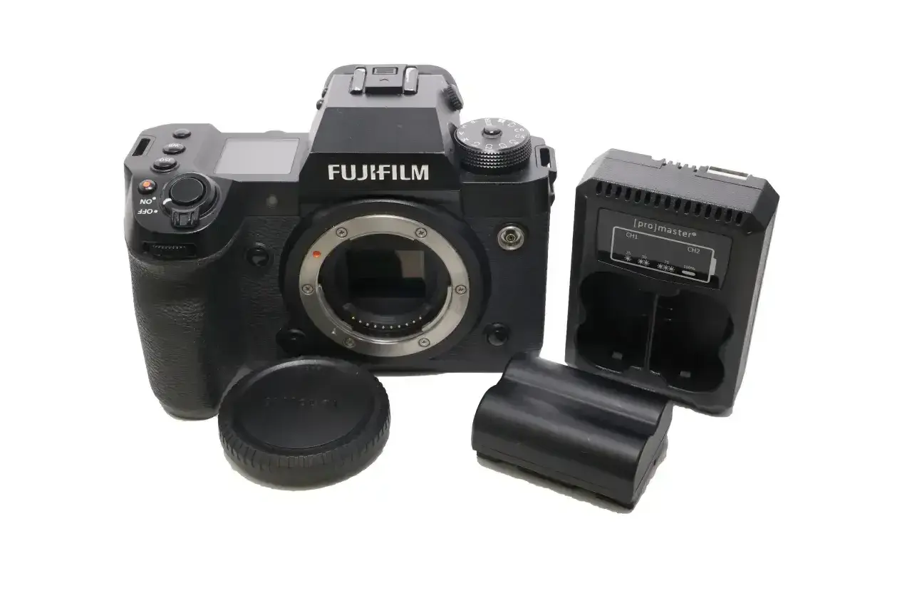 Aparat Fujifilm xh2s z obiektywem, ładowarką i bateriami.