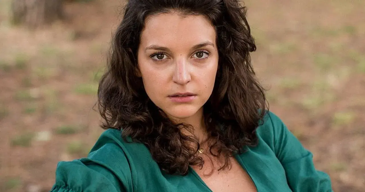 Maria Dębska w zielonej sukience, aktorka znana z wielu filmów, patrzy wprost na widza.