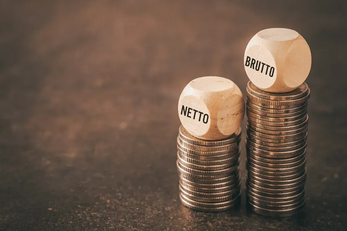 Dwie wieże monet, jedna z kostką "NETTO", druga z "BRUTTO". Czy to odzwierciedla średnią krajową netto?