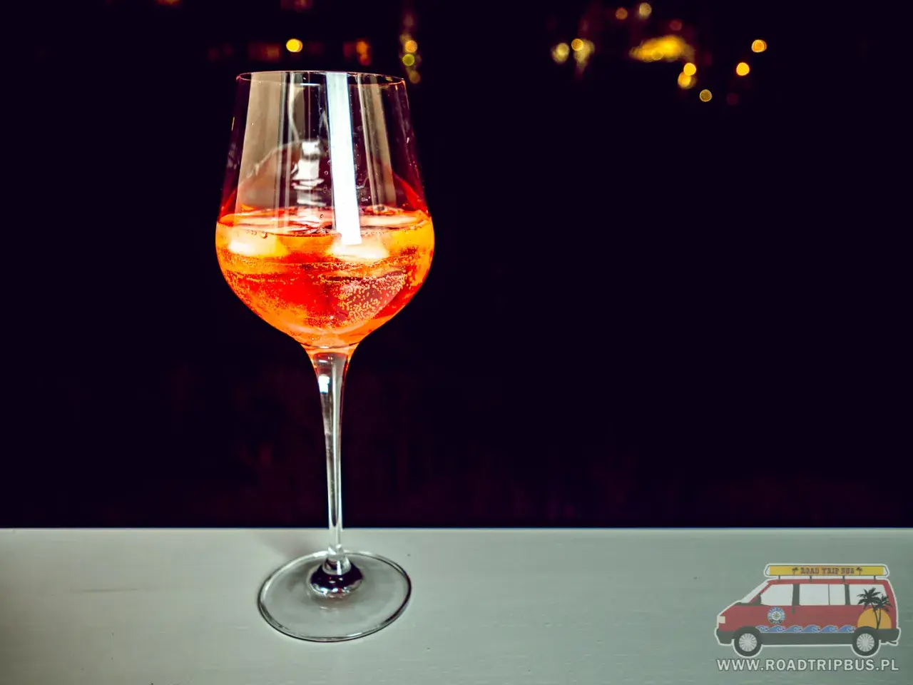 Orzeźwiający aperol z szampanem w kieliszku, z lodem i plasterkami pomarańczy. Idealny na letnie wieczory.