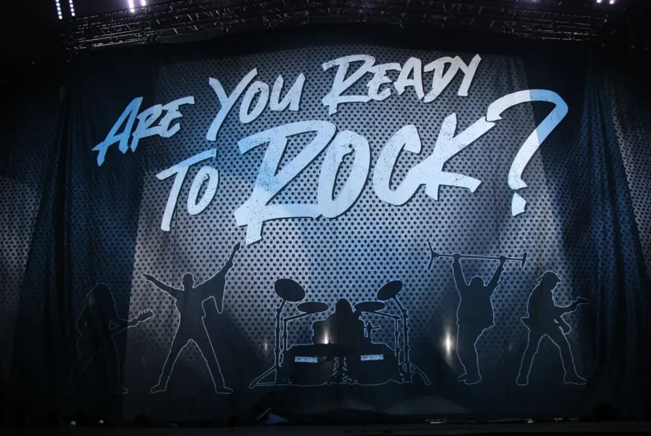 Scorpions w Krakowie gotowi do rocka! Napis "Are You Ready To Rock?" i sylwetki muzyków na scenie.
