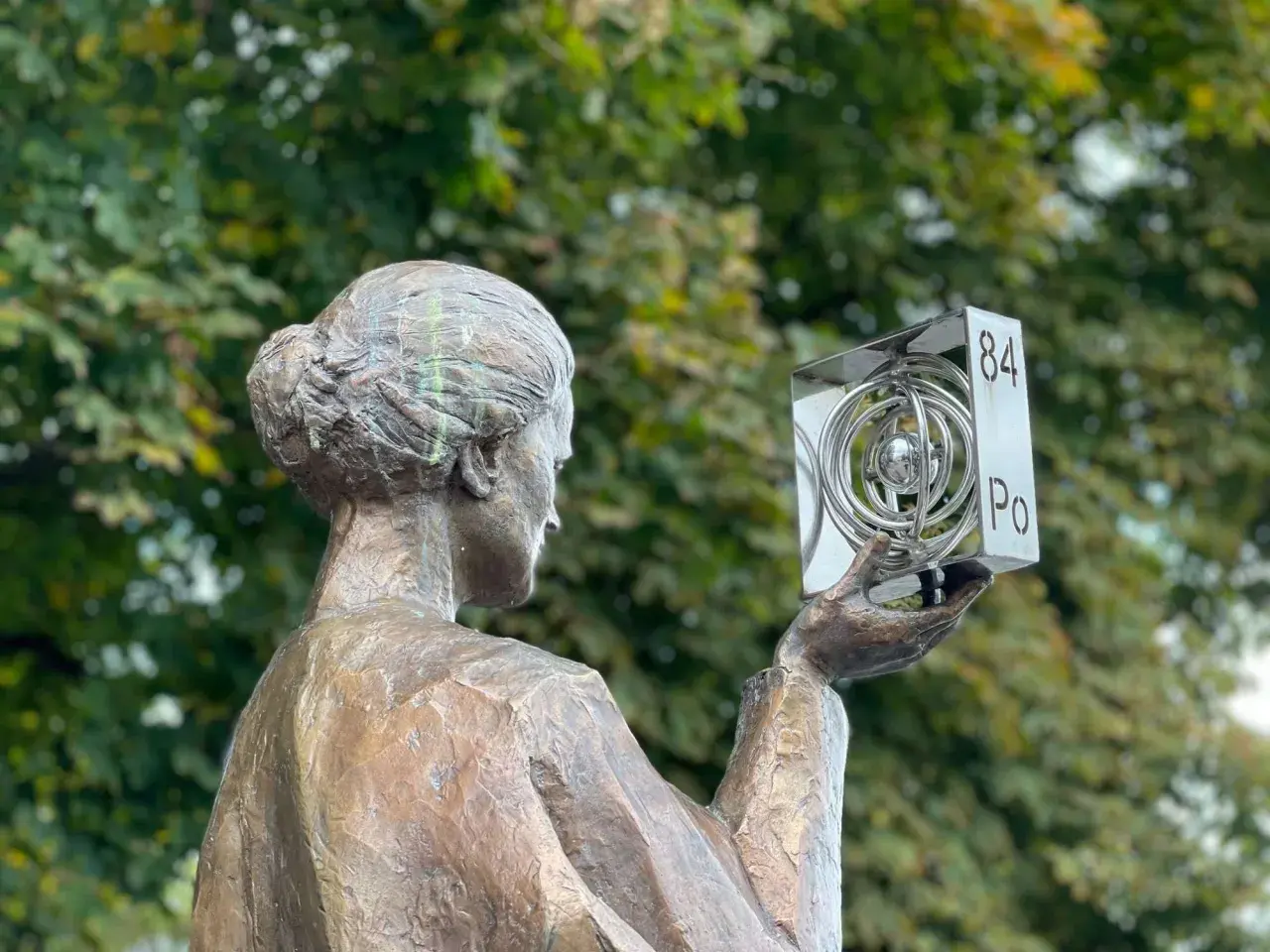 Pomnik Marii Skłodowskiej-Curie w Polsce, trzymająca symbol polonu (Po).