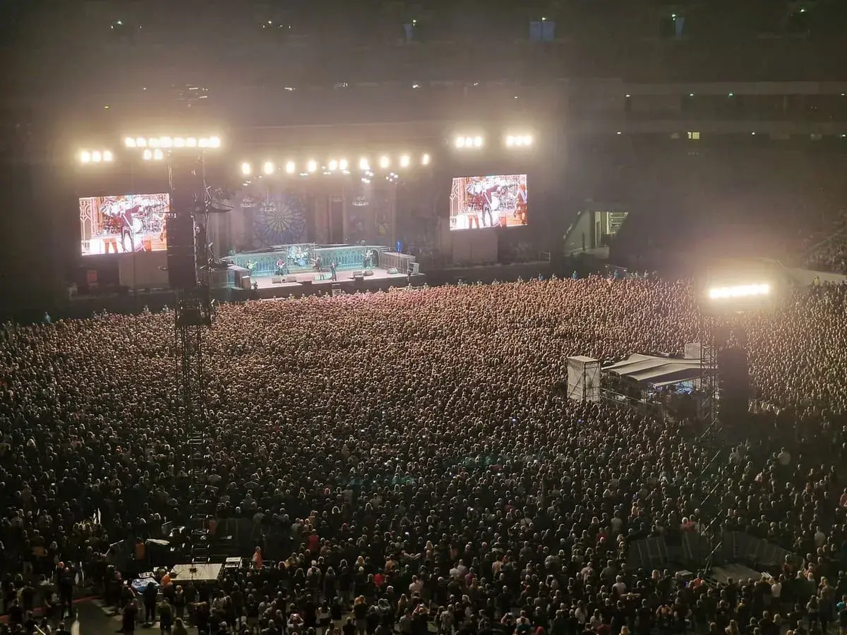 Ogromny tłum na koncercie Iron Maiden w Warszawie. Na scenie zespół, a na telebimach zbliżenia.