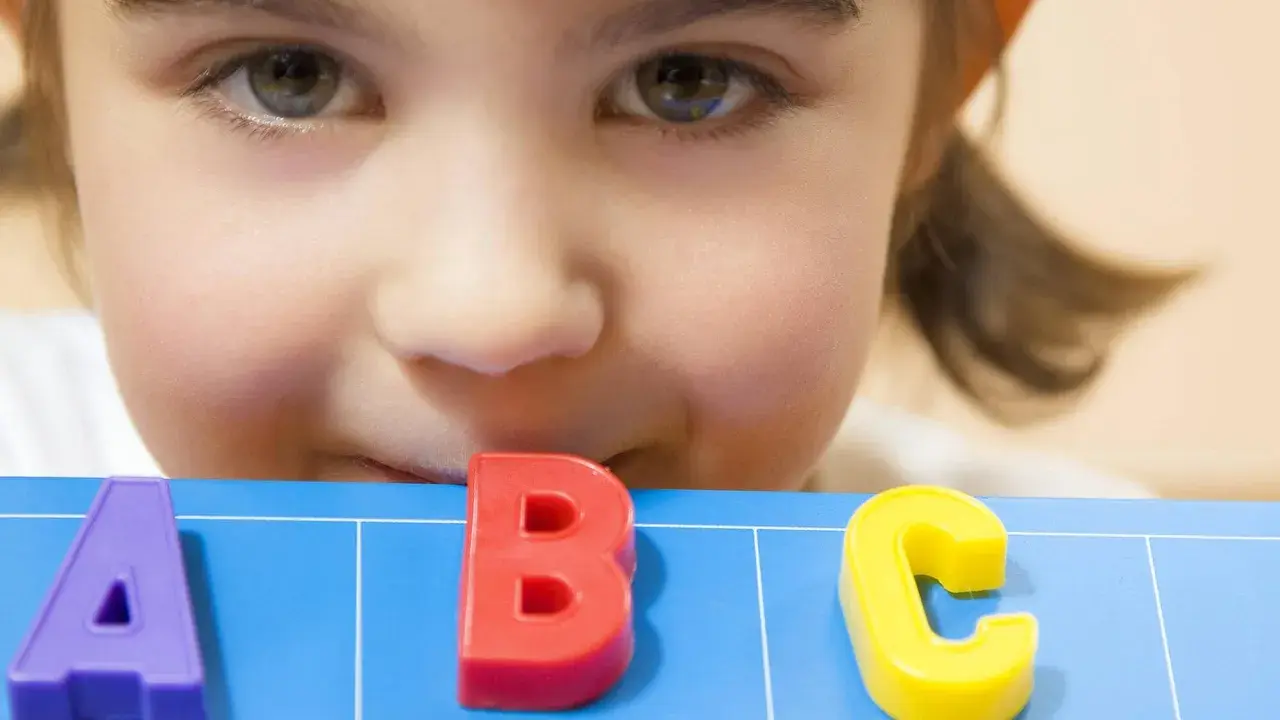 Ein neugieriges Kind lernt spielerisch das ABC. Perfekt für lustige Spiele zum Schulanfang!