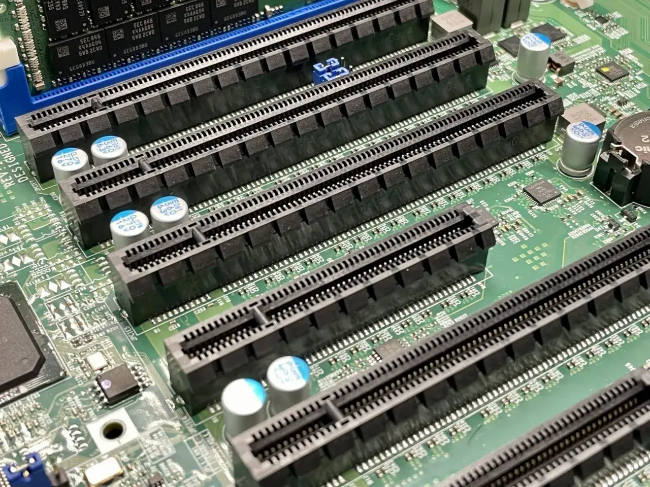 Szereg złączy PCI Express (PCIe) na płycie głównej, gotowych na nowe karty rozszerzeń. Widać różnice między starszymi standardami PCI a nowszymi PCIe.