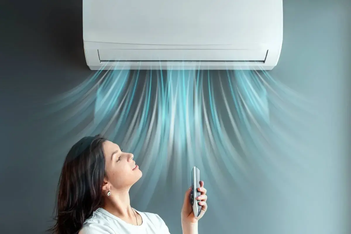 Donna gode dell'aria fresca da un condizionatore 12000 BTU. Il costo installazione condizionatore 12000 btu è un investimento per il comfort.