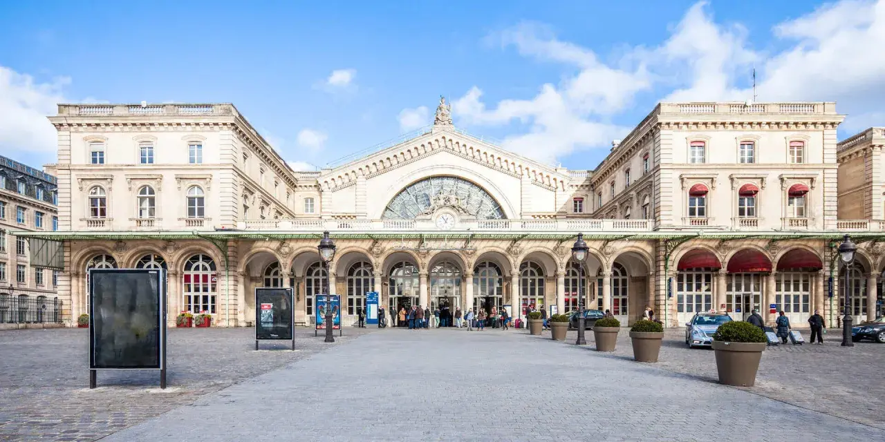 Prachtvoller Bahnhof in Paris Zentrum mit Bögen und einer großen Uhr.