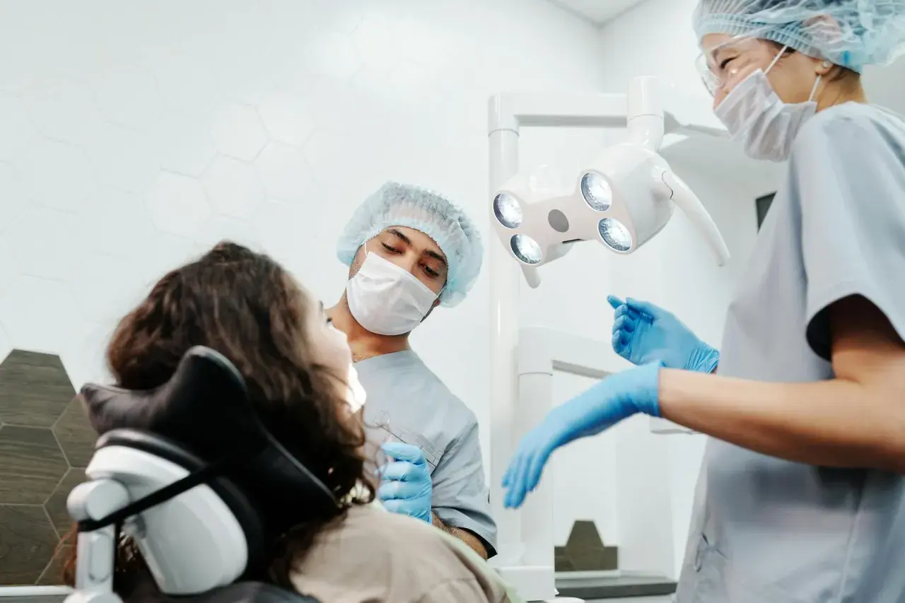 Dentysta bada zęby pacjentki, która ma widoczną dziurę w zębie.