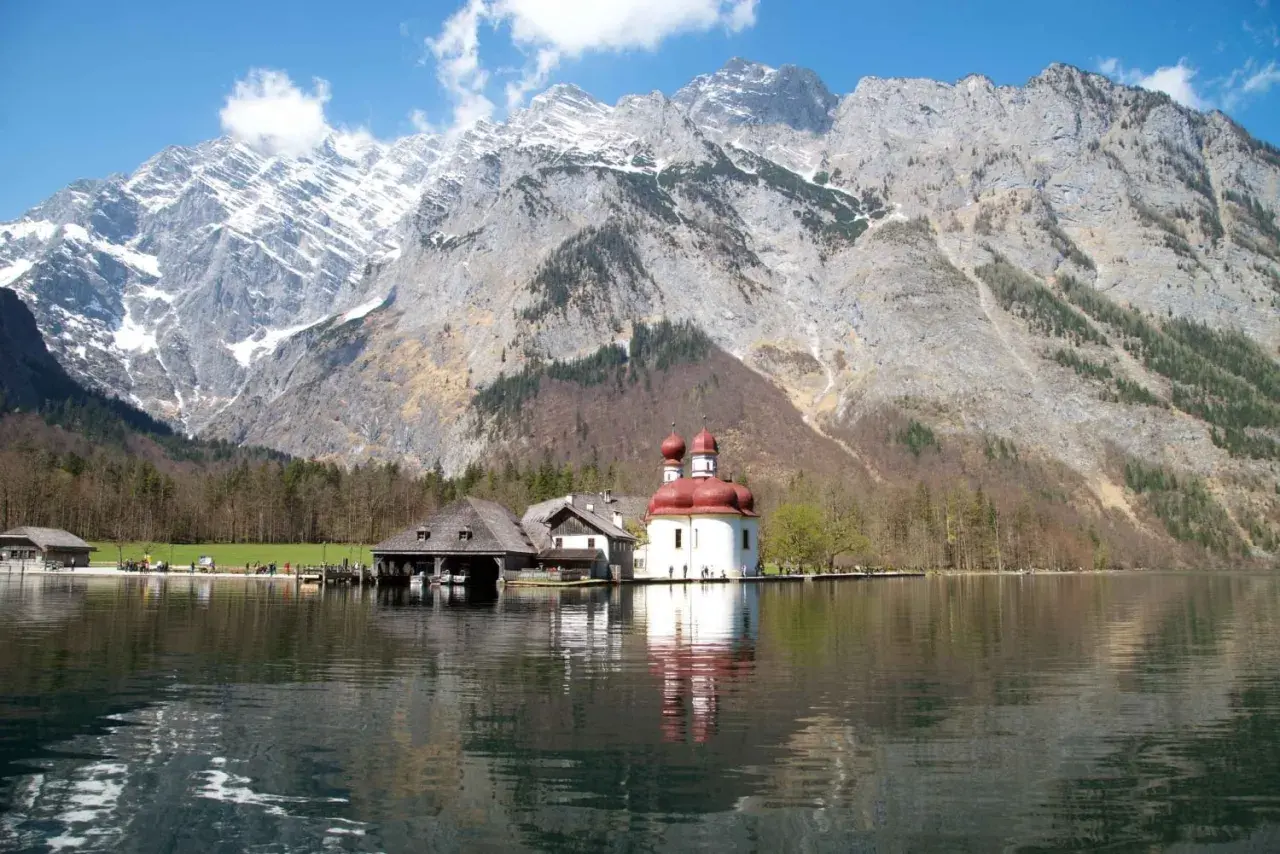 Jezioro Königssee z kościołem św. Bartłomieja i majestatycznymi monachijskimi górami w tle.